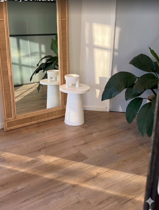 Minimal white treatment room with rattan mirror and monstera plant